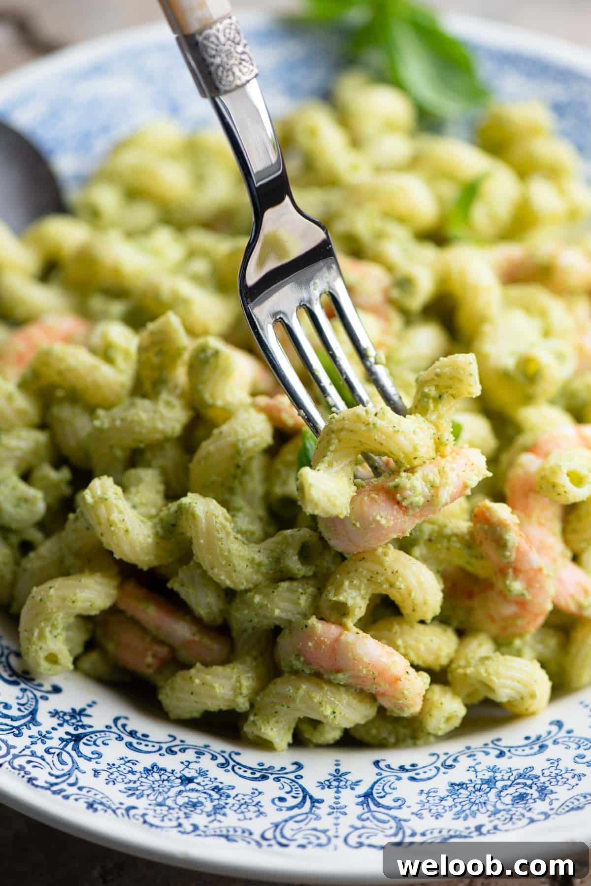 A close up of zucchini pasta and shrimp on a fork.