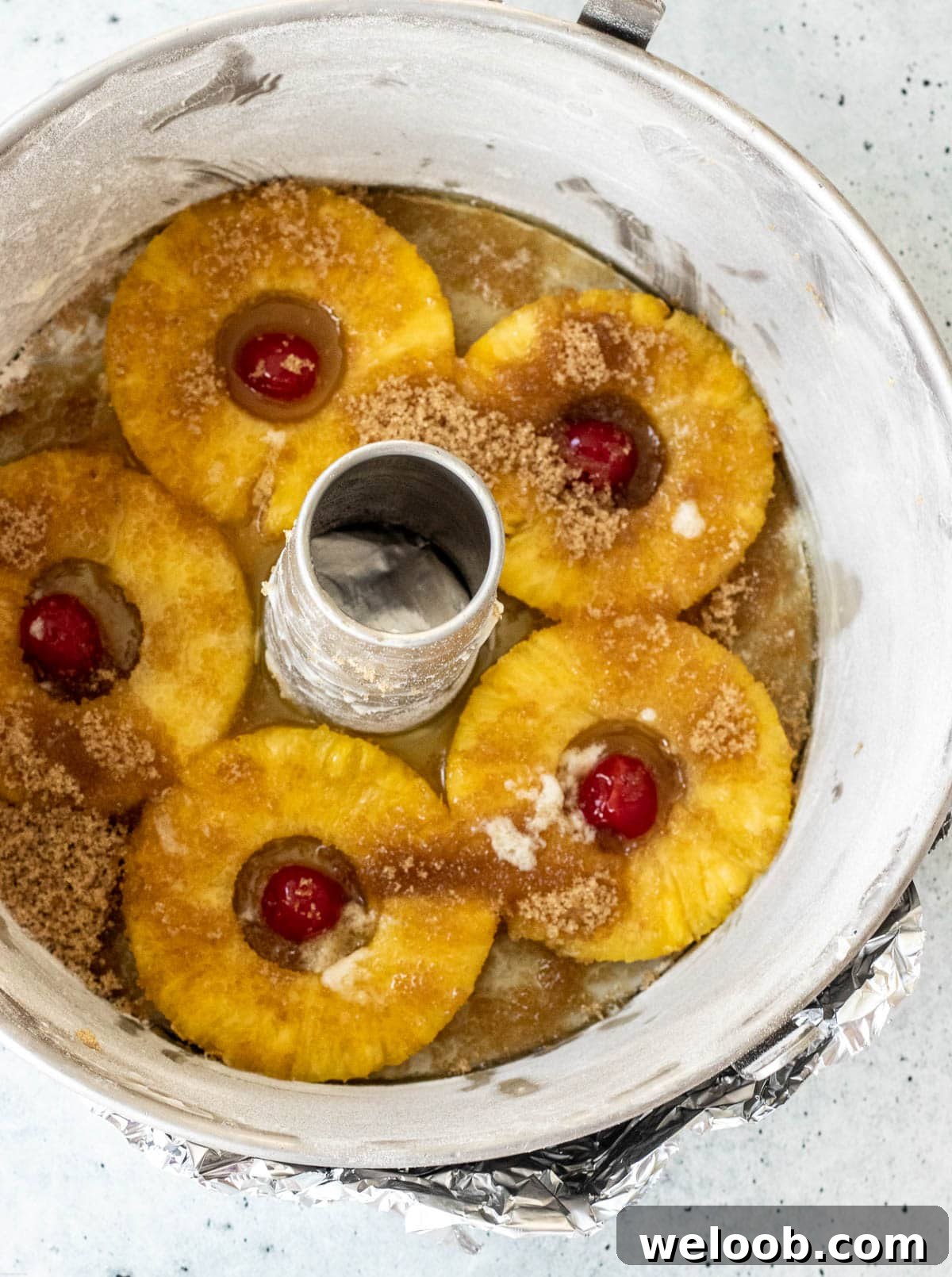 Baking pan covered at the bottom with pineapple rings, maraschino cherries, brown sugar and melted butter.
