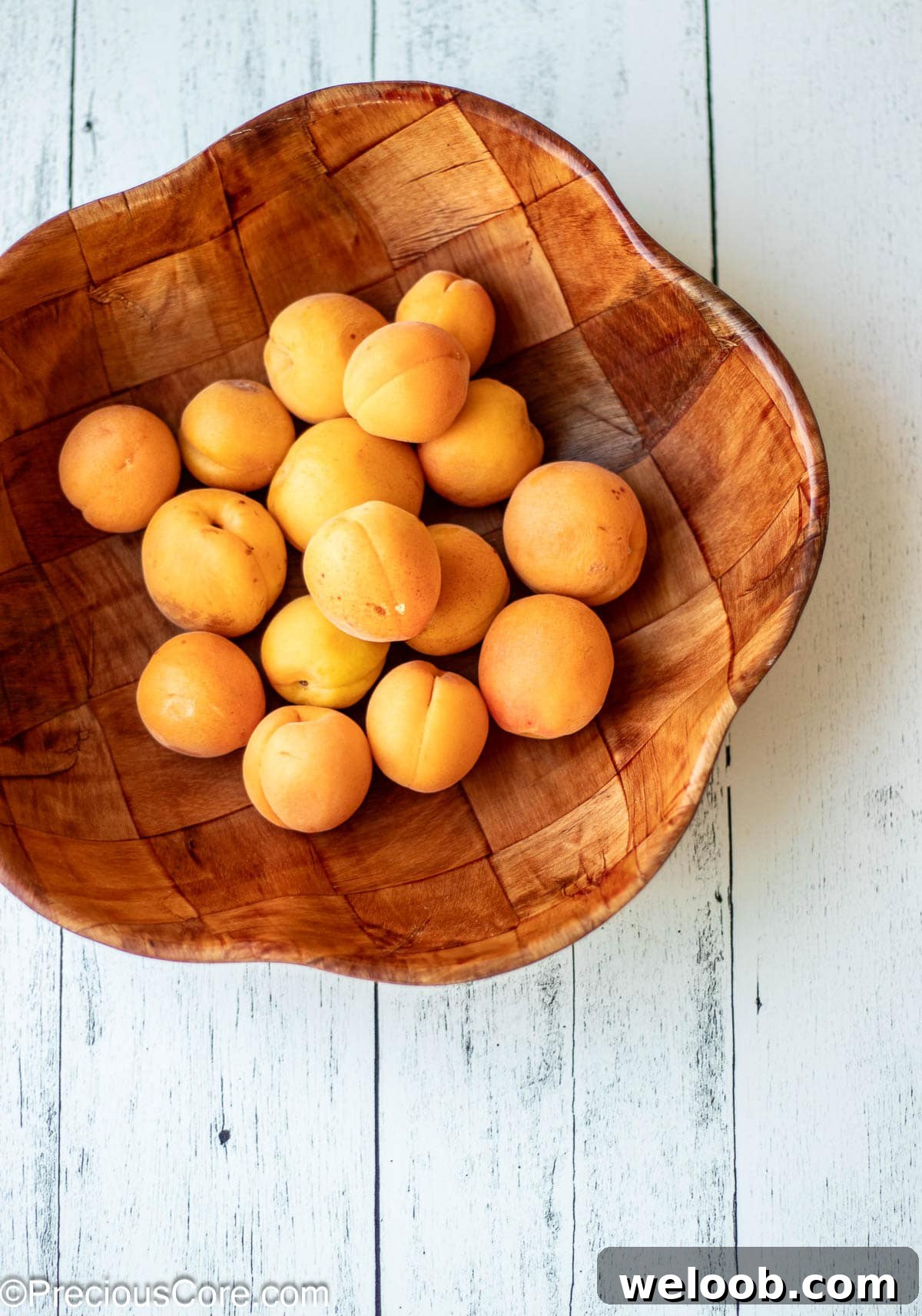 A wooden bowl of apricots.