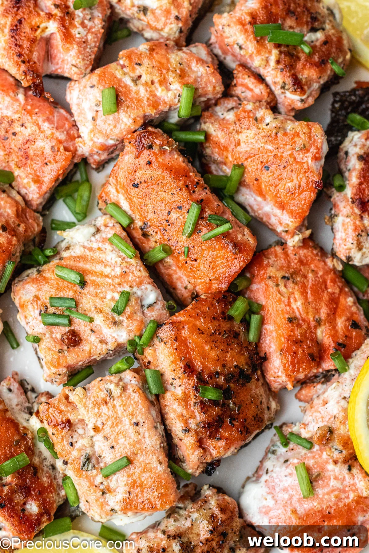 About 1-inch sized salmon bites on a white plate.