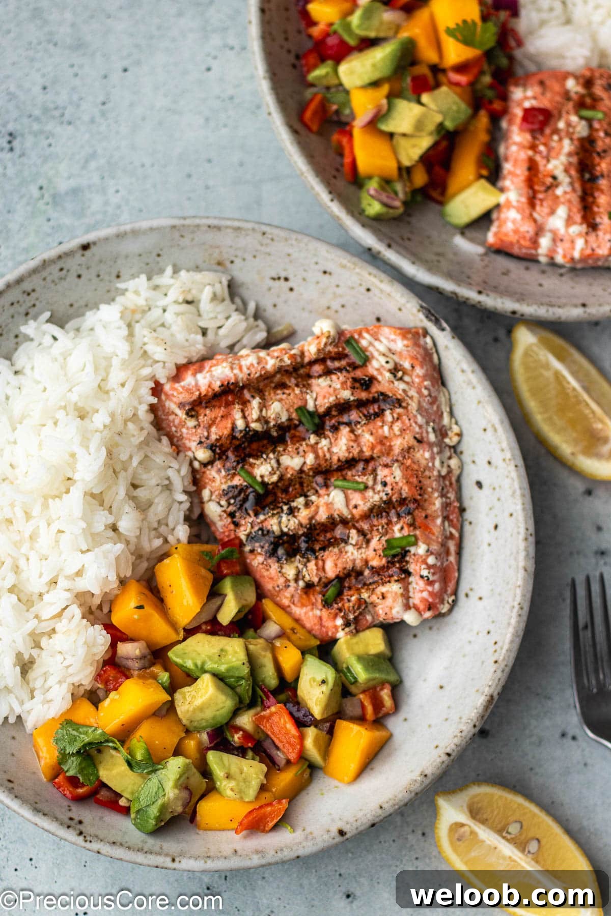 Grilled sockeye salmon in a bowl with rice and Mango Salsa.
