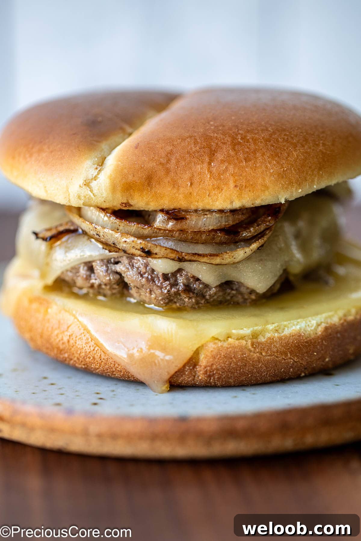 A grilled onion cheddar burger on a plate.