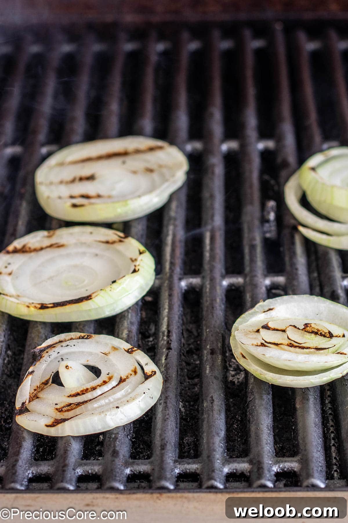 Round slices of onions on a grill.