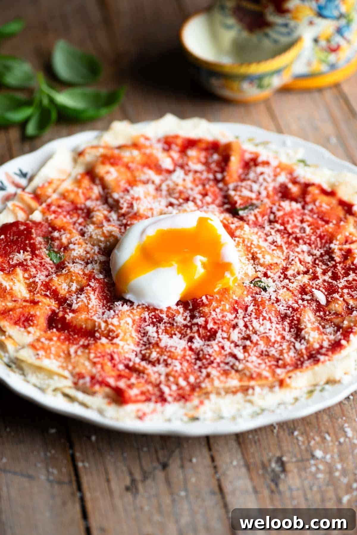 Pane Frattau on a plate (tomato and bread) topped with a poached egg.