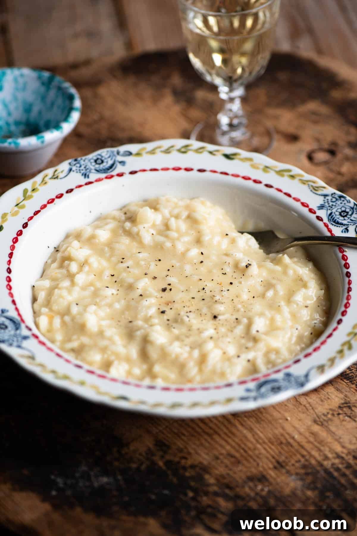 A bowl of cheesy Risotto alla valdostana sitting on a wooden board.