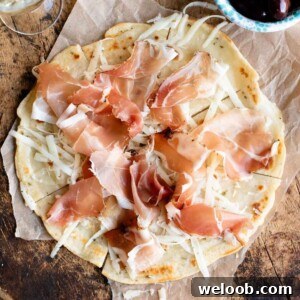 A close up cropped image of Brustengo, an Italian flatbread topped with meat and cheese.