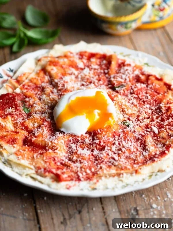 Pane Frattau on a plate (tomato and bread) topped with a poached egg.