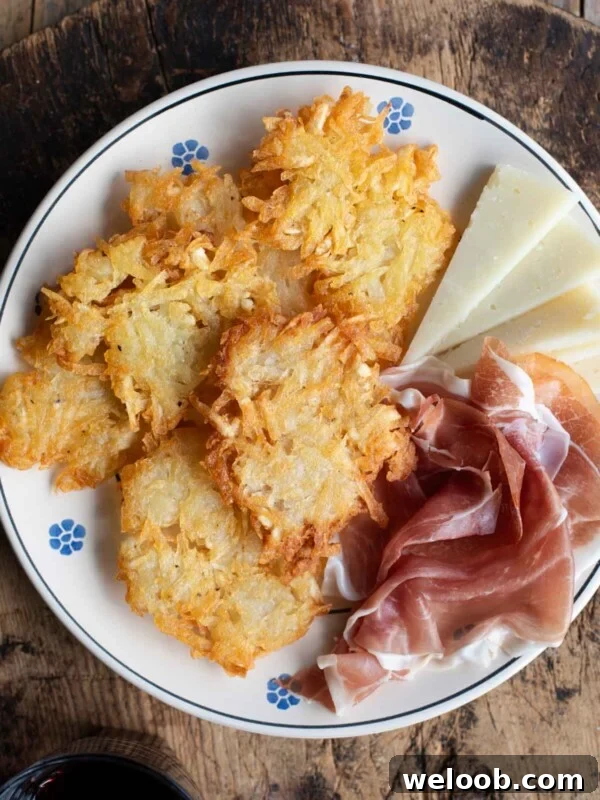 An overhead shot of Italian potato fritters on a plate with some cured meat and cheese.
