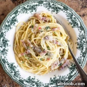 A close up cropped image on Spaghetti alla Molisana with pancetta, onion and chilli in a green patterned bowl.