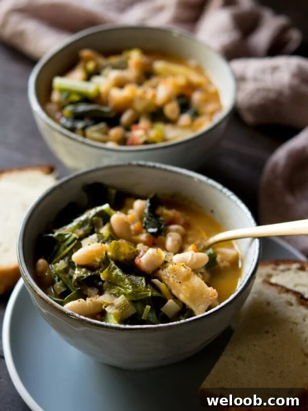Tuscan vegetable soup in a bowl with bread in background