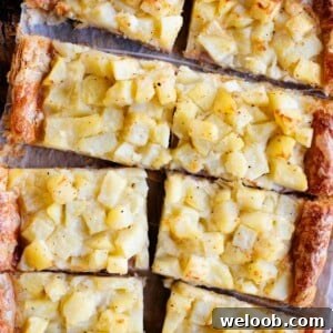 A cropped overhead image of a puff pastry potato tart cut into slices.