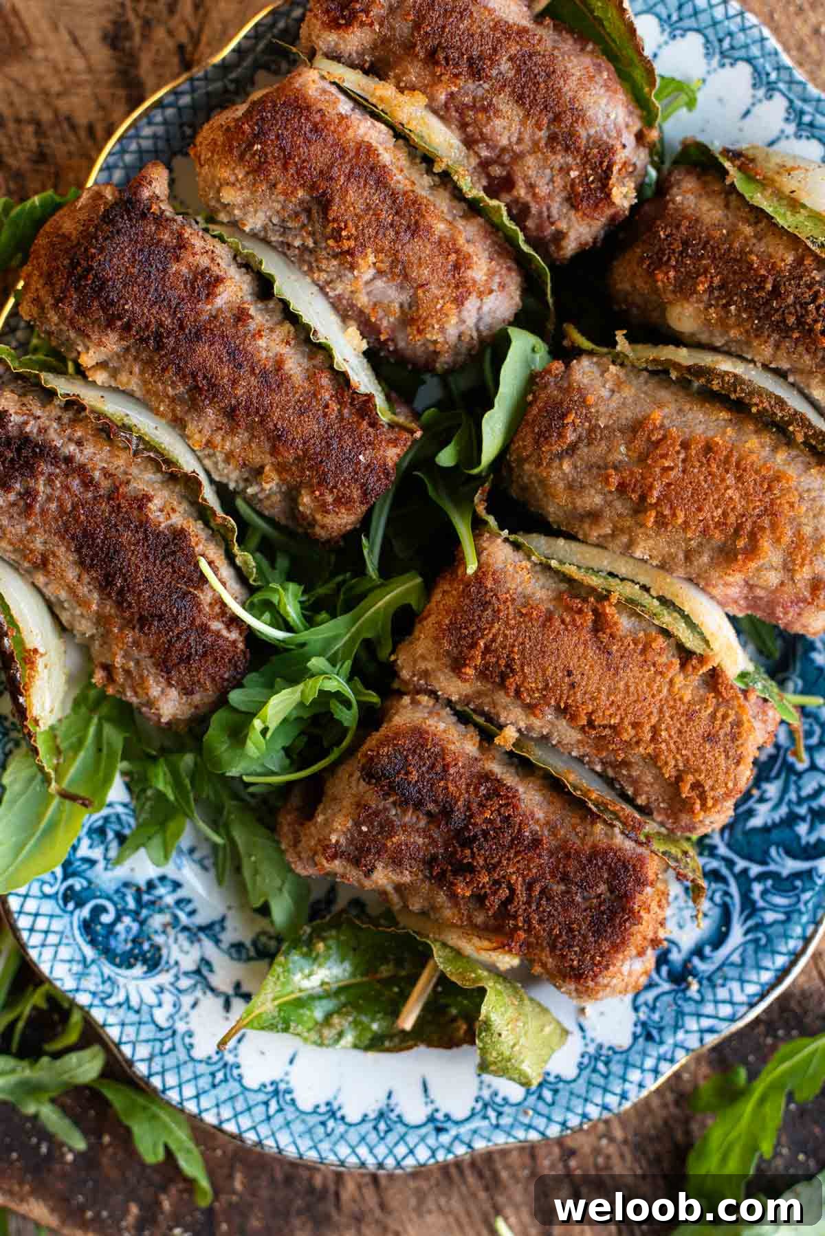 An overhead shot of Sicilian involtini on skewers with breadcrumbs.