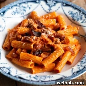 A close up of pasta alla zozzona in a blue and white bowl.