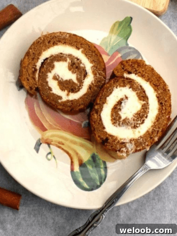 Two slices of pumpkin roll cake on a plate with a fork.