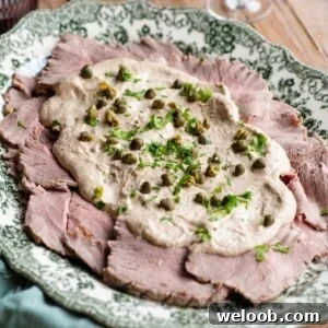 A cropped image of vitello tonnato on a serving platter.