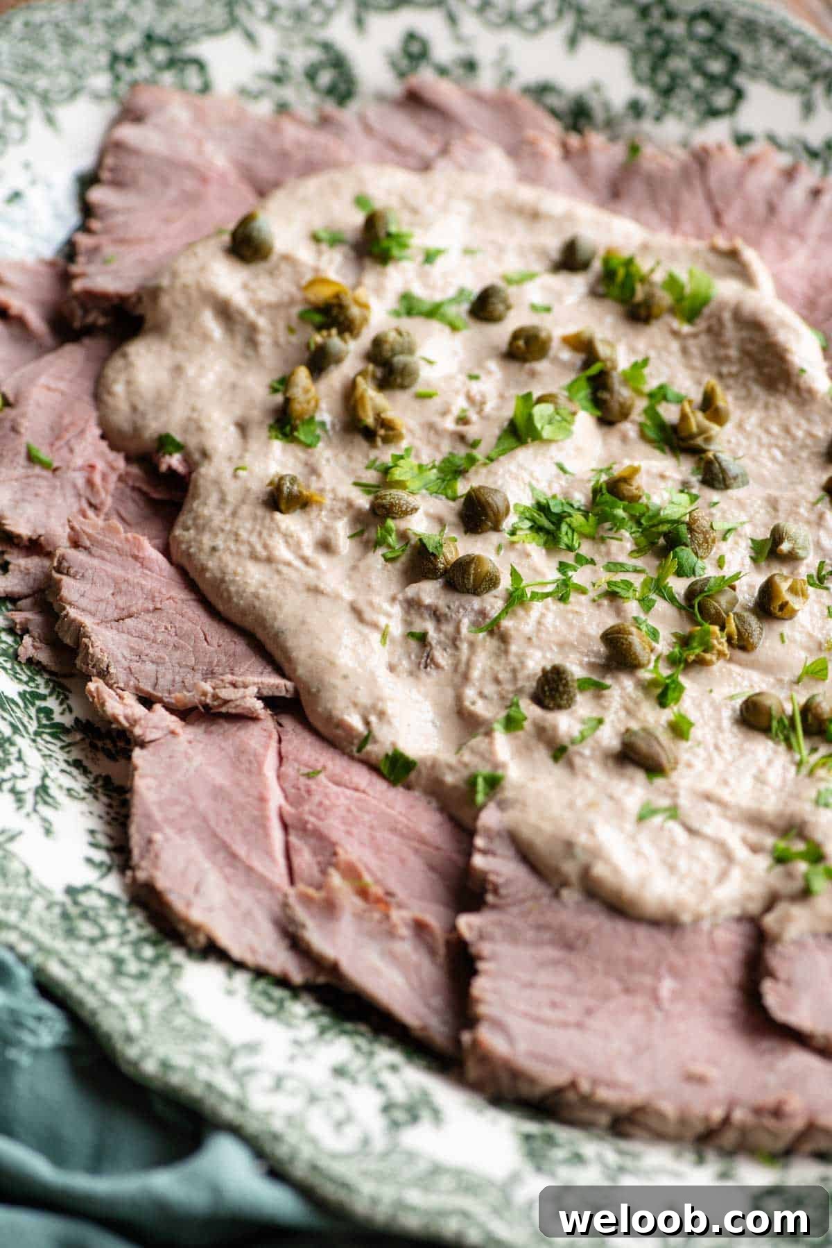 A close up of Vitello Tonnato on a serving dish.