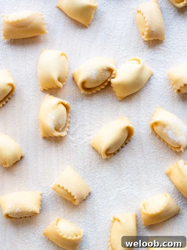 An overhead shot of Agnolotti pasta on a wooden board.