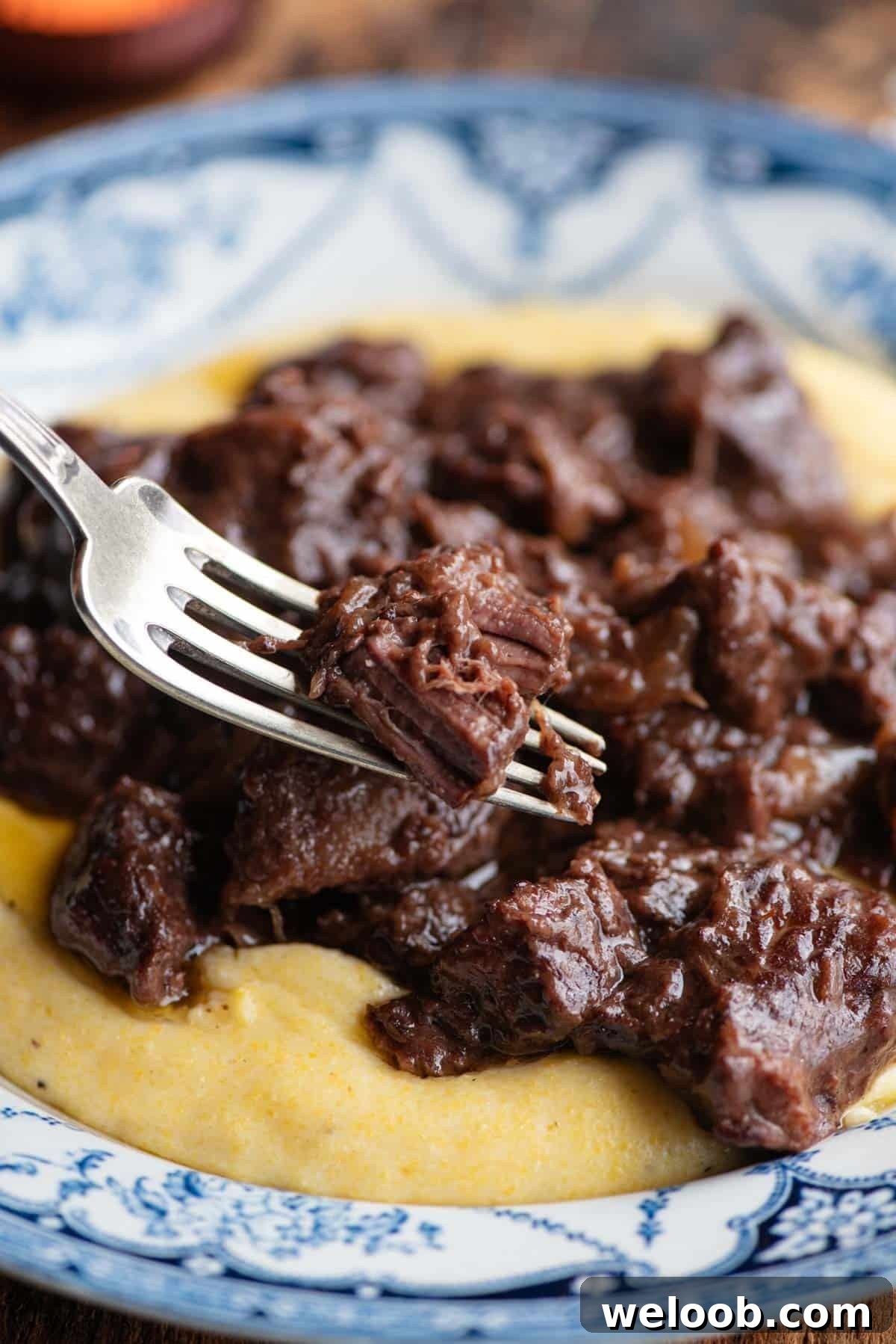 A close up of Italian beef stew on a fork.