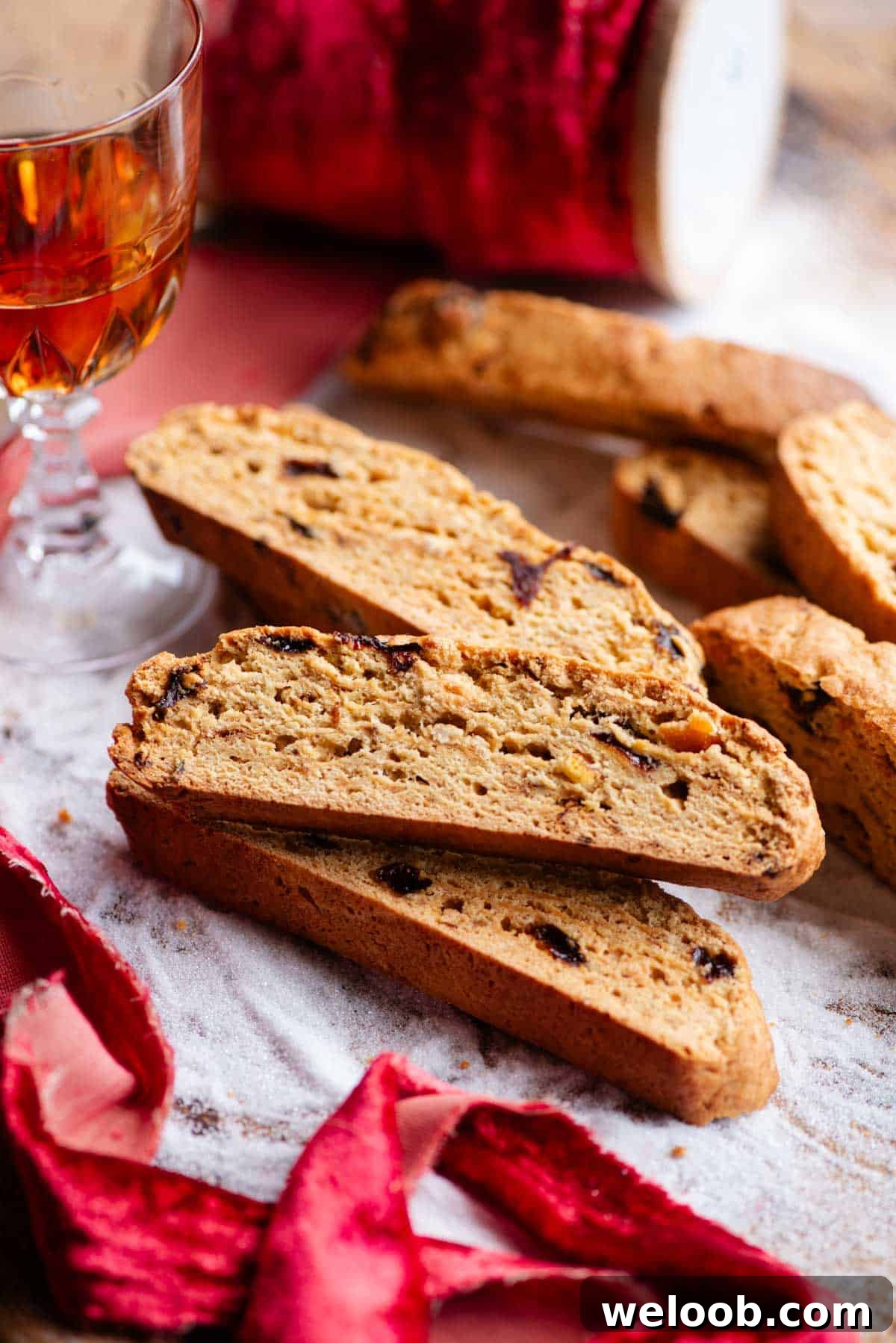 A close up side shot of Panettone Biscotti on a wooden board covered with sugar.