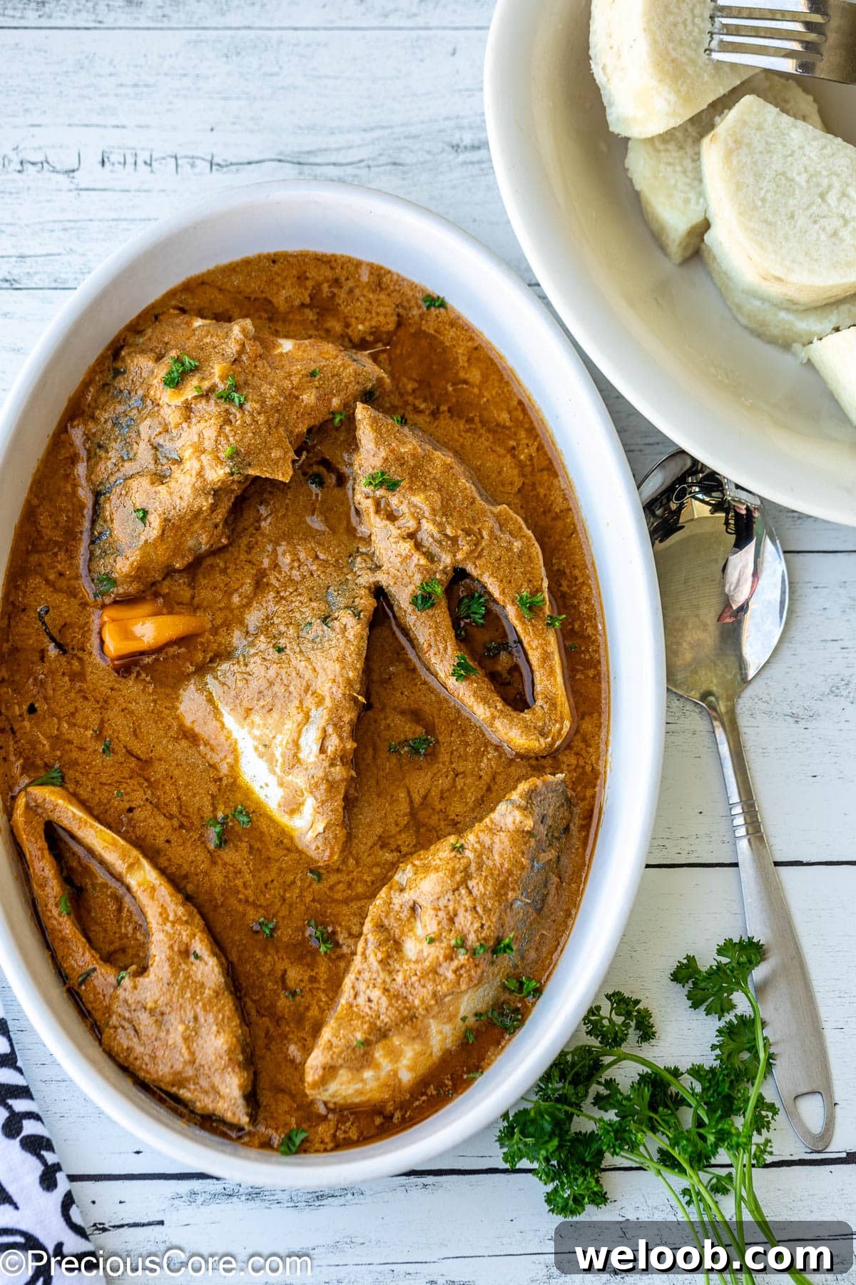 Njangsa Sauce Recipe from Cameroon: How to Make Authentic Njansa Stew 2 Njangsa sauce in a white oval bowl with white yams on the side.