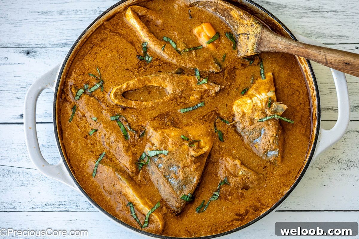Njangsa Sauce Recipe from Cameroon: How to Make Authentic Njansa Stew 6 A white pot filled with stew and fish steaks.