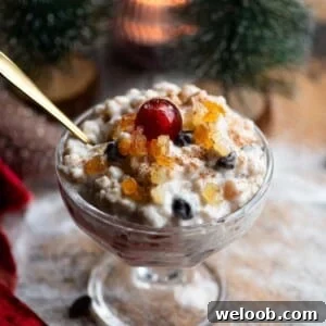 A close up of Cuccia, a Sicilian ricotta dessert in a small glass bowl topped with candied fruit.