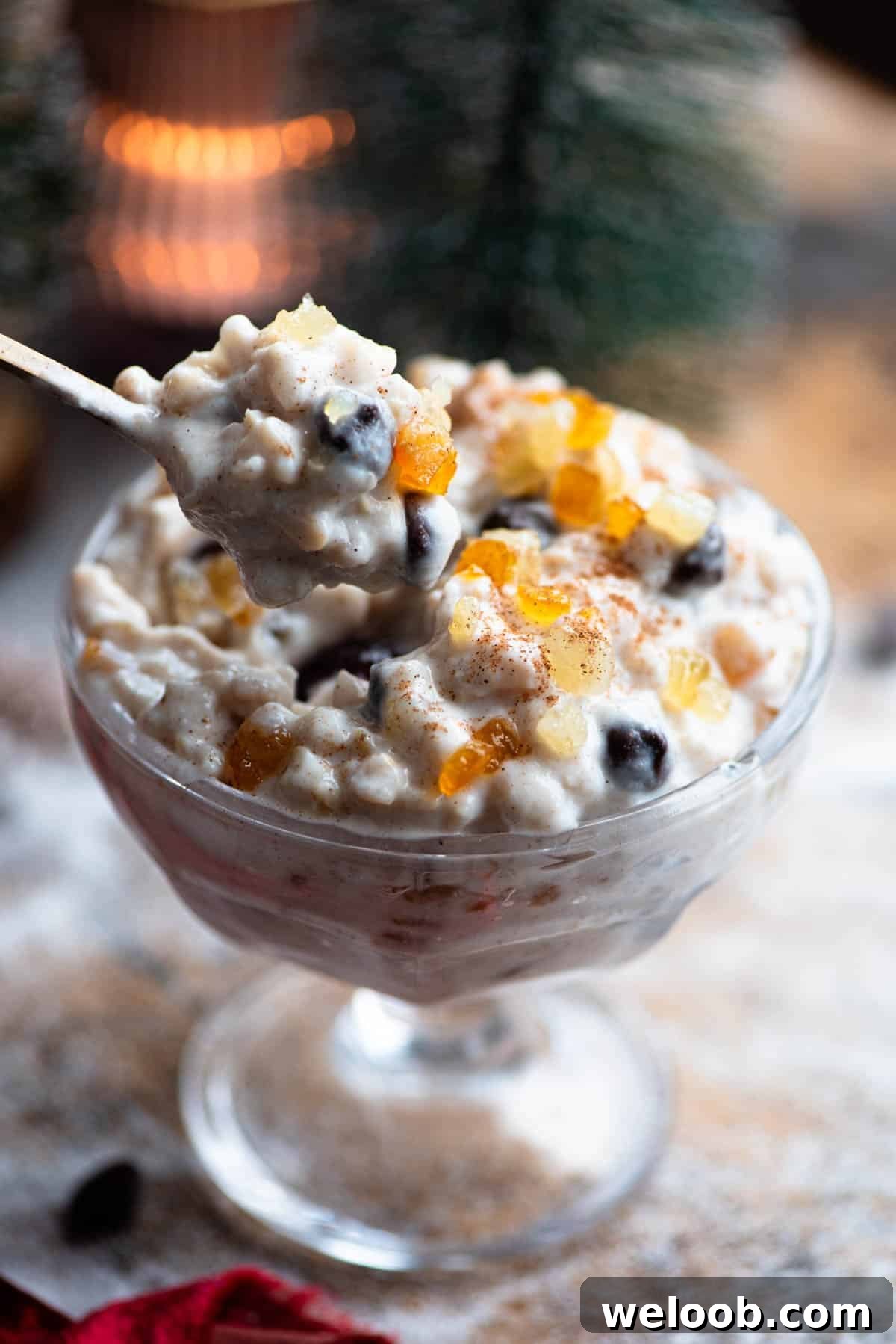 A spoon picking up a creamy ricotta grain dessert from a glass bowl.