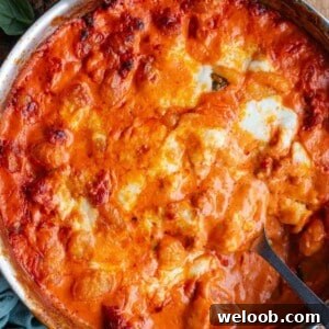 A close up cropped image of spicy sausage baked gnocchi in a skillet.