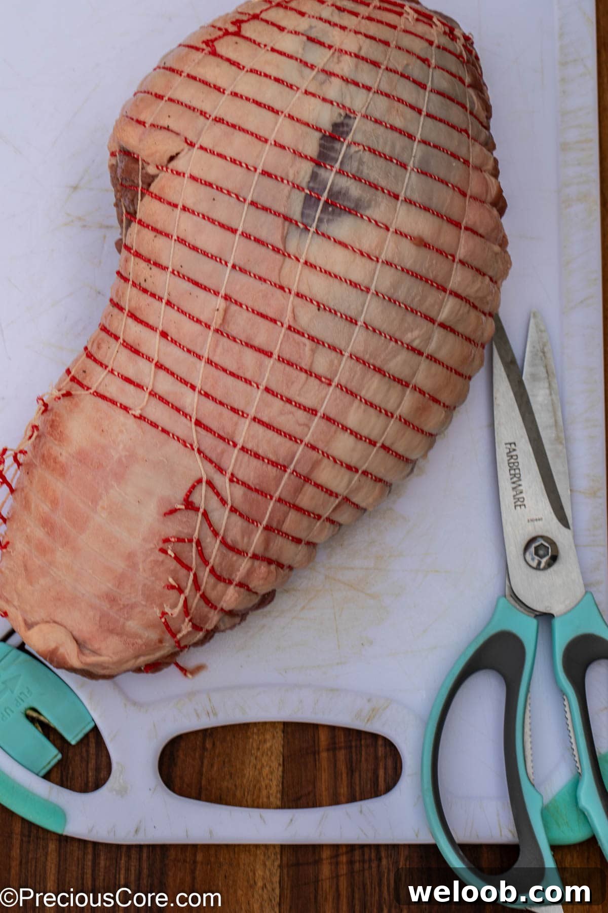 Cutting off covering from roast.