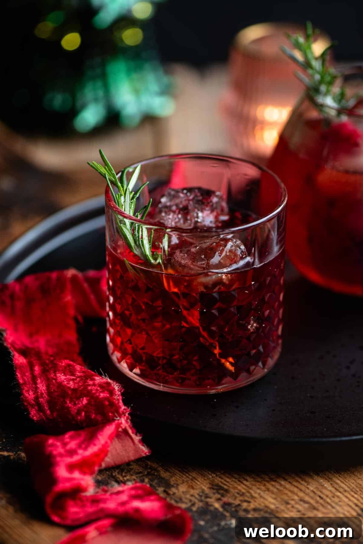 A red negroni sbagliato cocktail in a glass with a sprig of rosemary.