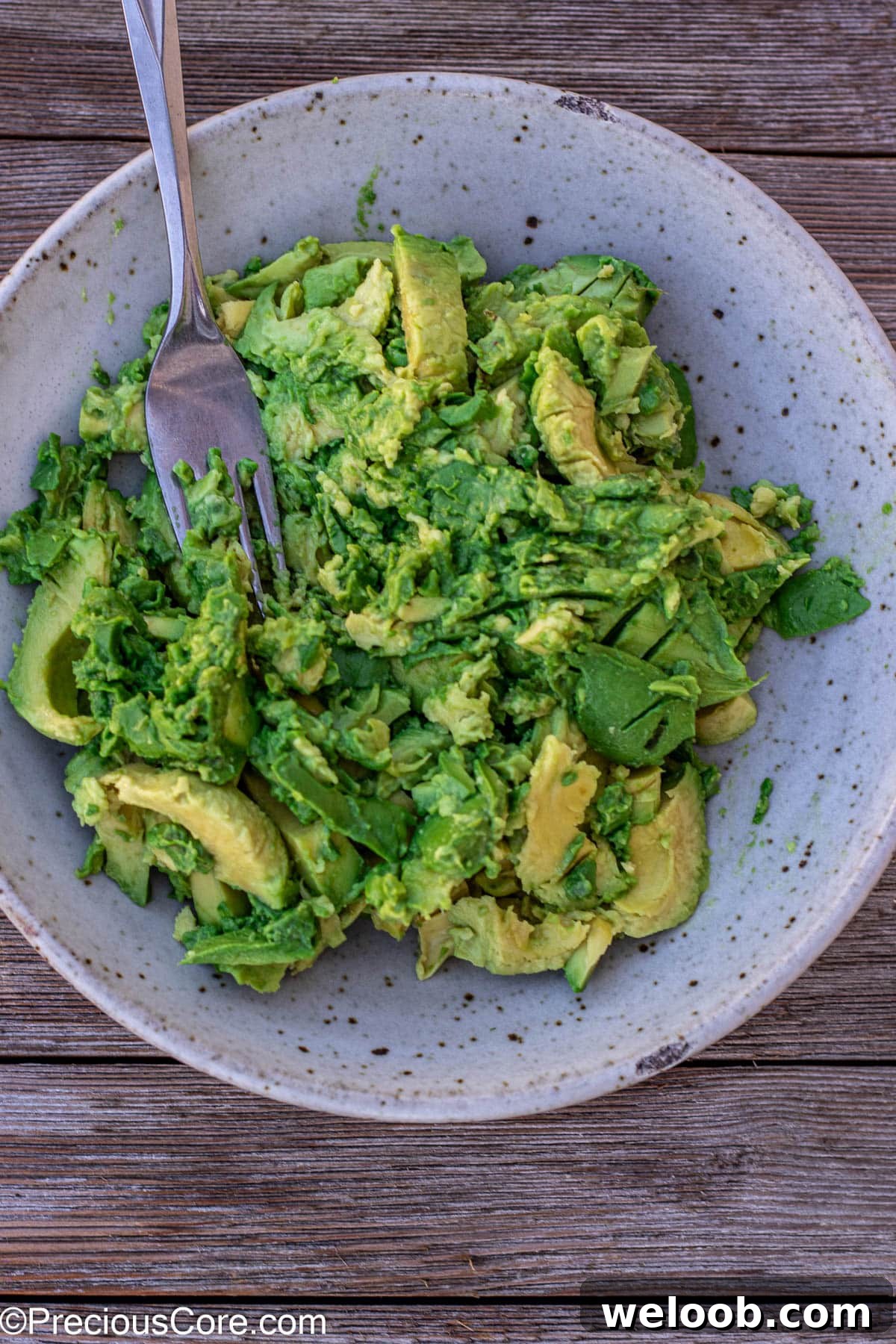 Mashing avocados with a fork.