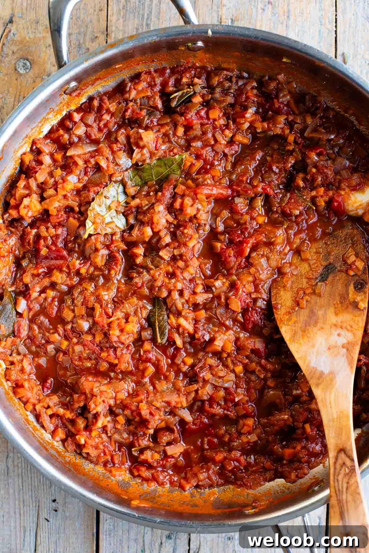 Sugo Finto: Authentic Italian Vegetable Pasta Sauce Recipe 2 An overhead shot of a skillet with an Italian slow cooked vegetable sauce sitting on a wooden table.