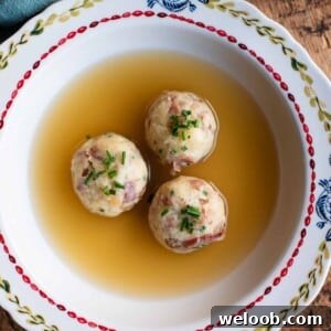 A cropped square image of Canederli dumplings in meat broth.