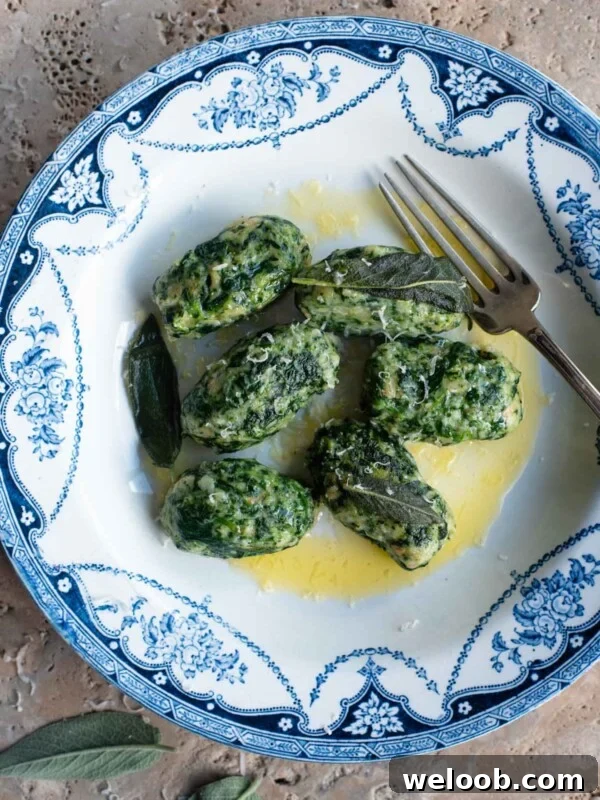 An overhead shot of Strangolapreti (Italian bread dumplings) on a blue and white plate.
