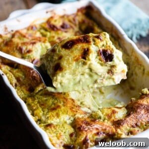 A close up of a spatula picking up a slice of pistachio lasagna from a baking dish.