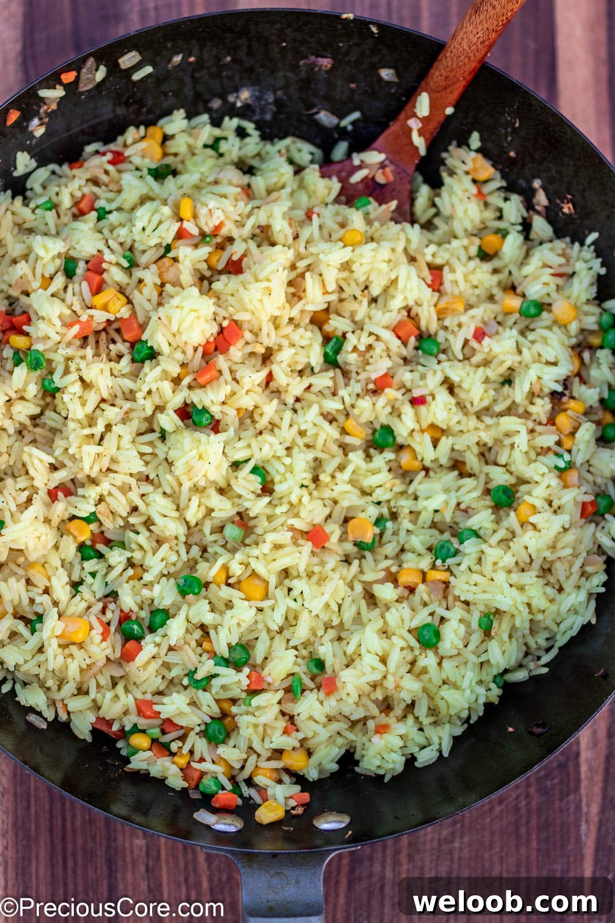 Rice stir-fried with vegetables in a wok.