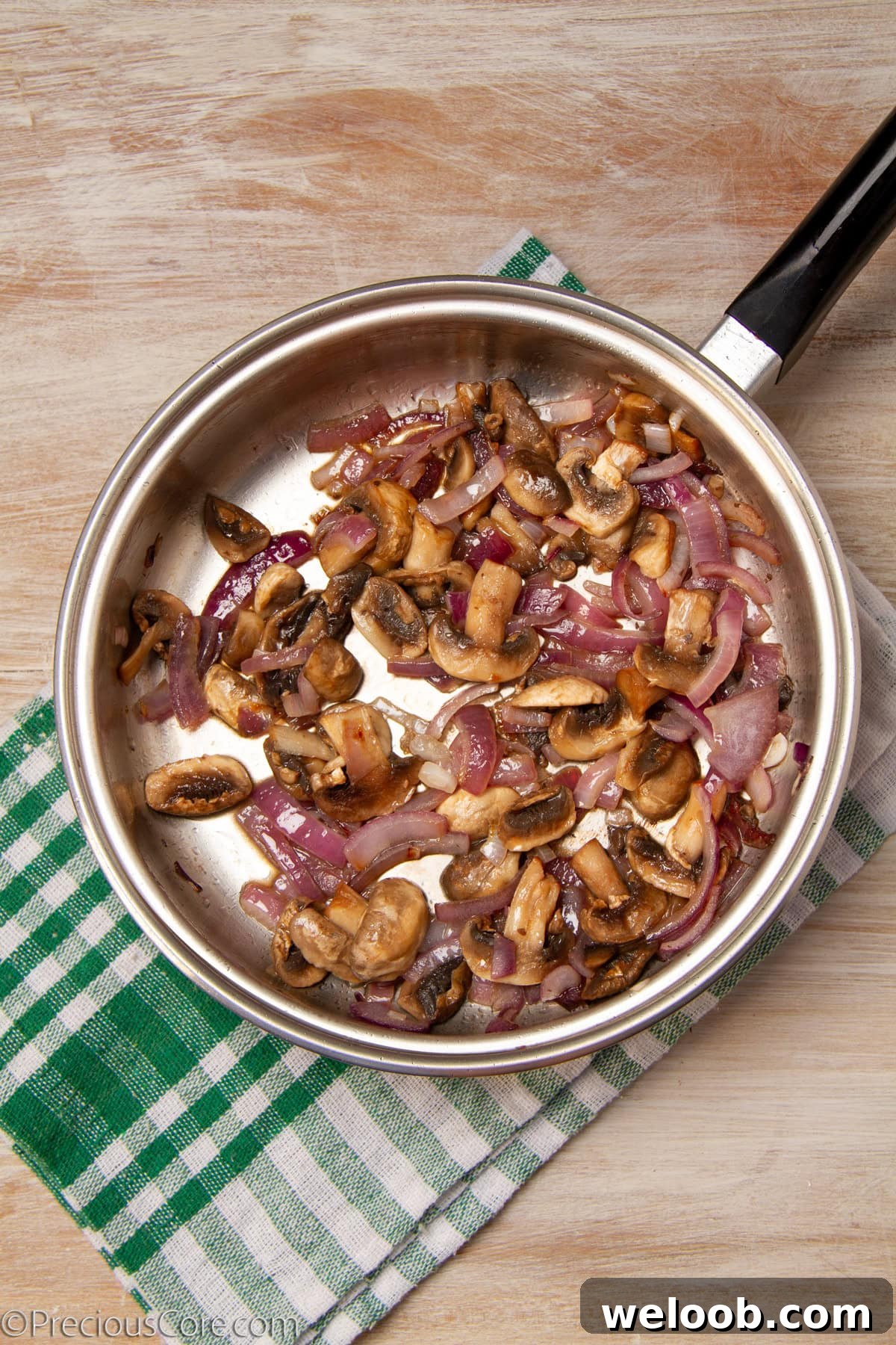 Onions and mushrooms in a pan.