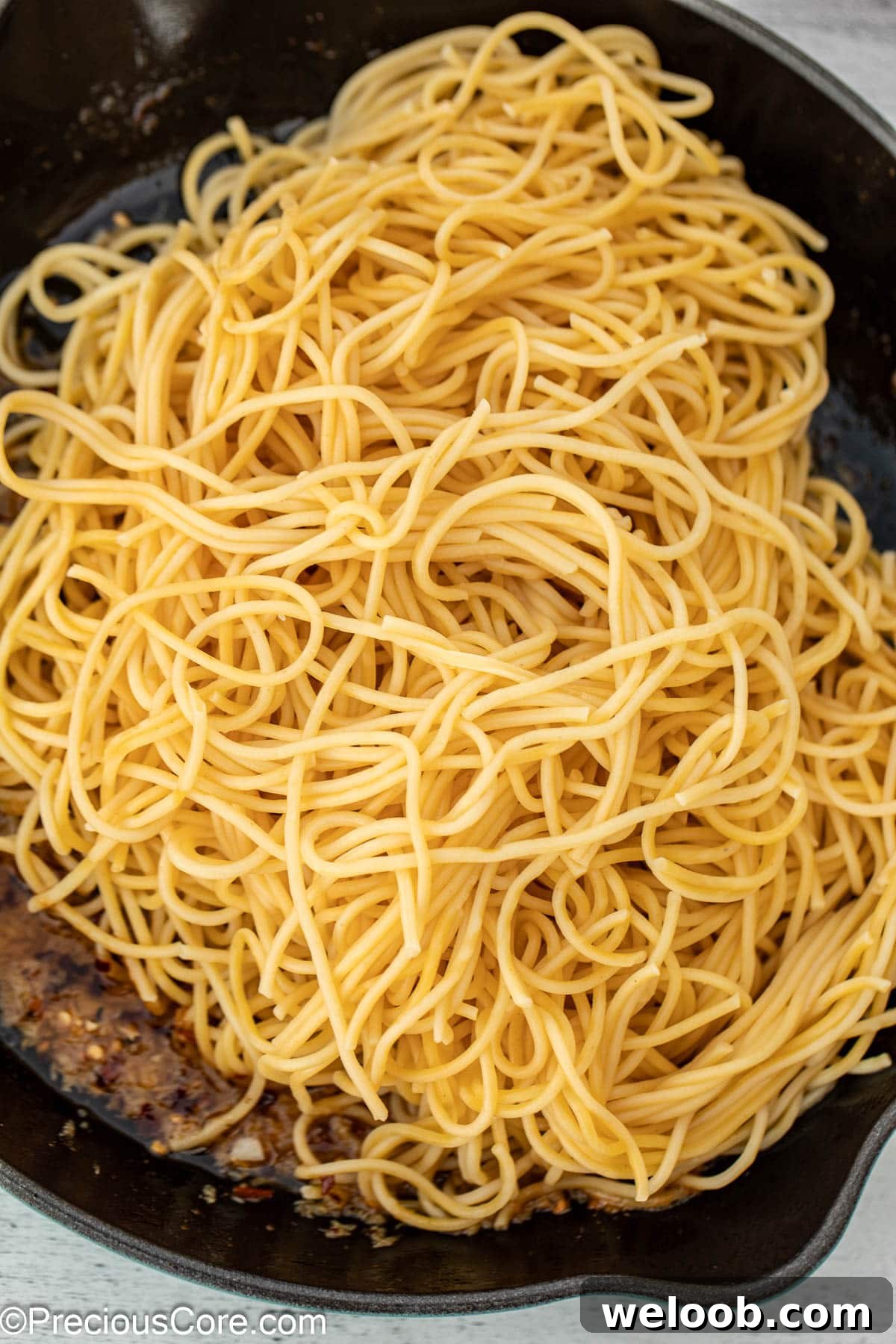 Spaghetti in cast iron pan with garlic sauce.