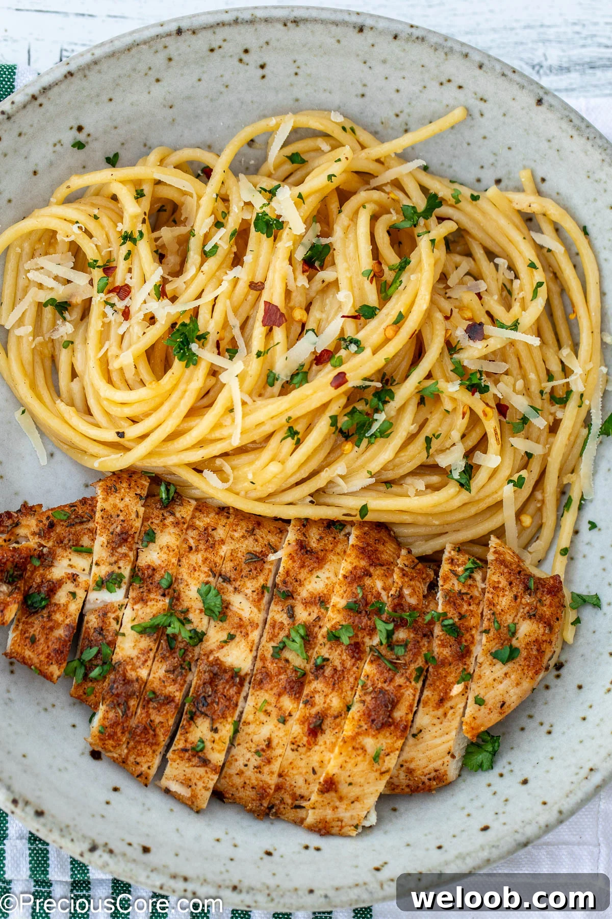 Garlic butter pasta and chicken breast in a bowl.