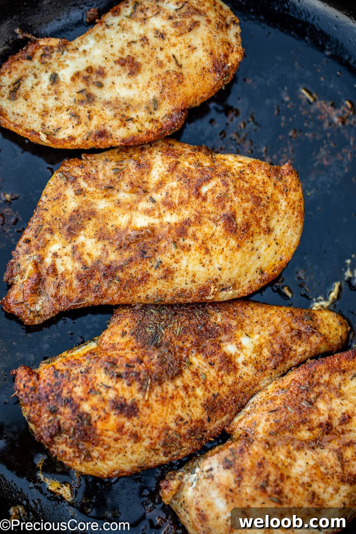 Pan seared chicken breasts in a skillet.