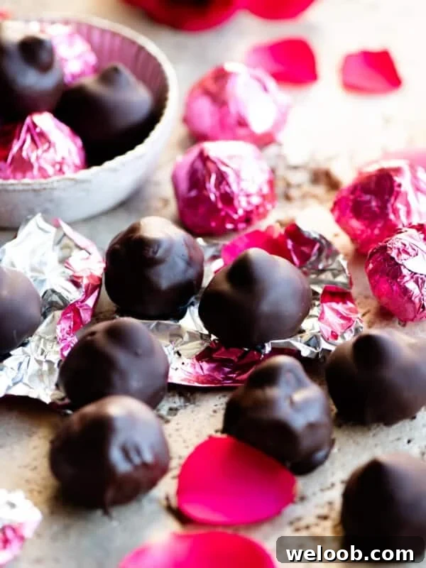 Homemade Italian baci chocolates on a travertine worktop with pink foil wrappers.