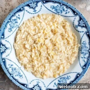 An overhead cropped image of lemon risotto in a blue and white bowl.