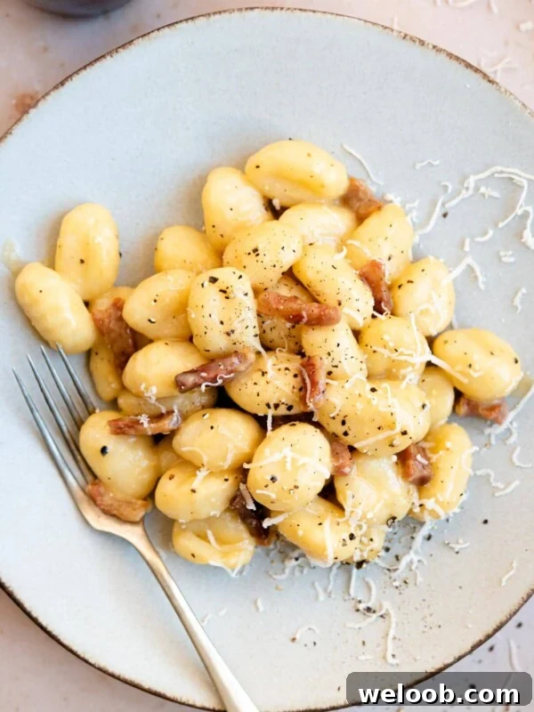 An overhead shot of a plate of gnocchi with carbonara sauce