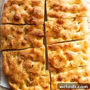 Golden, rustic and bubbly focaccia cut into 8 slices.