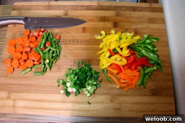 Poulet DG Recipe: How to Make Cameroon’s Classic Chicken Dish 15 Colorful chopped vegetables on a wooden cutting board.