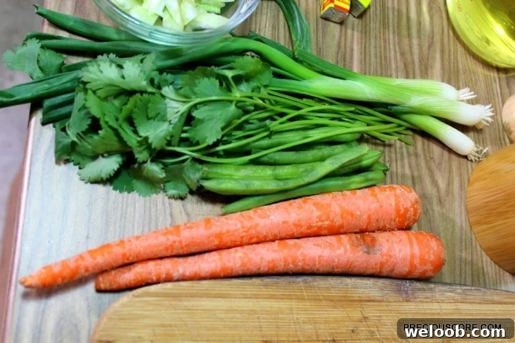 Poulet DG Recipe: How to Make Cameroon’s Classic Chicken Dish 9 Carrots, green beans, and other produce on a wooden cutting board.