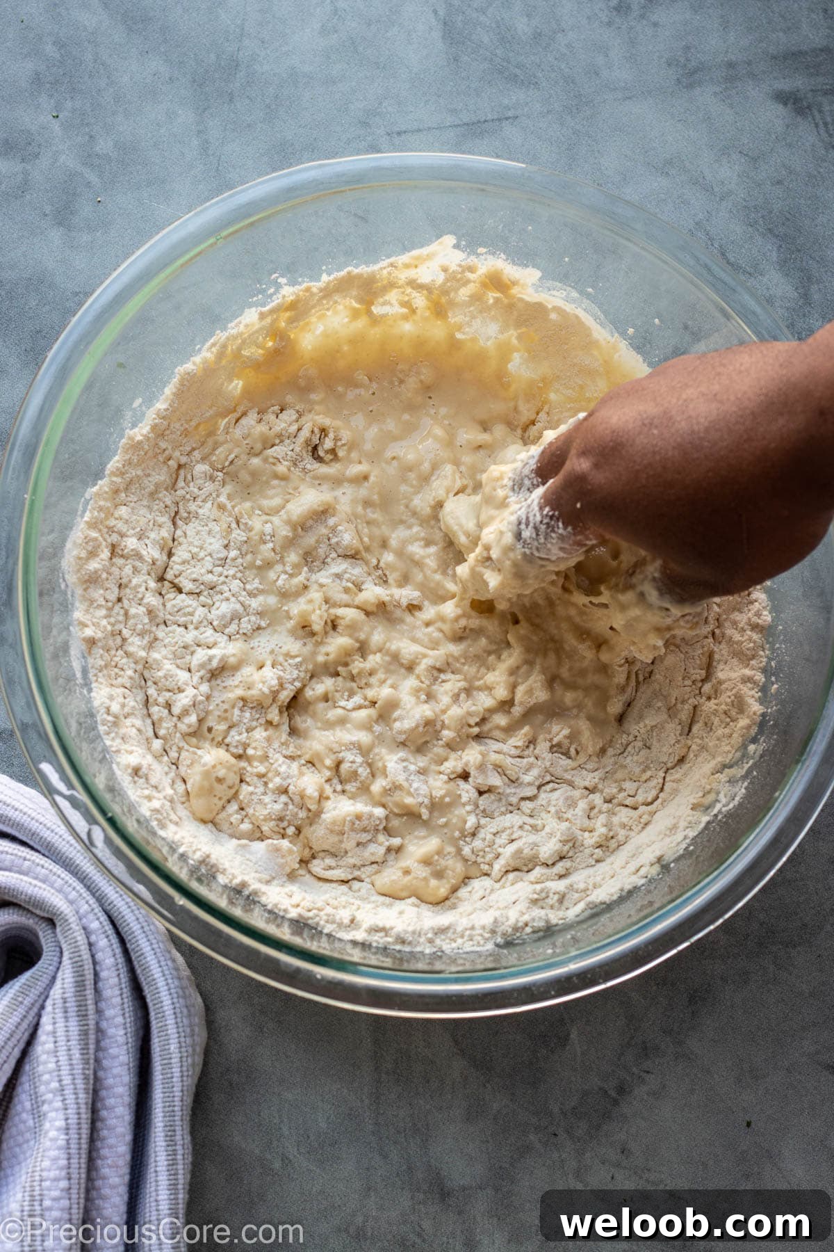 Hand mixing Puff Puff in bowl.