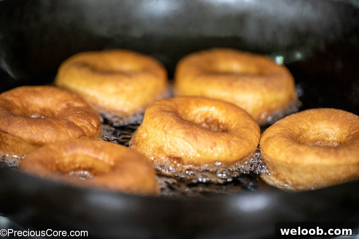 Golden brown donuts frying in oil.