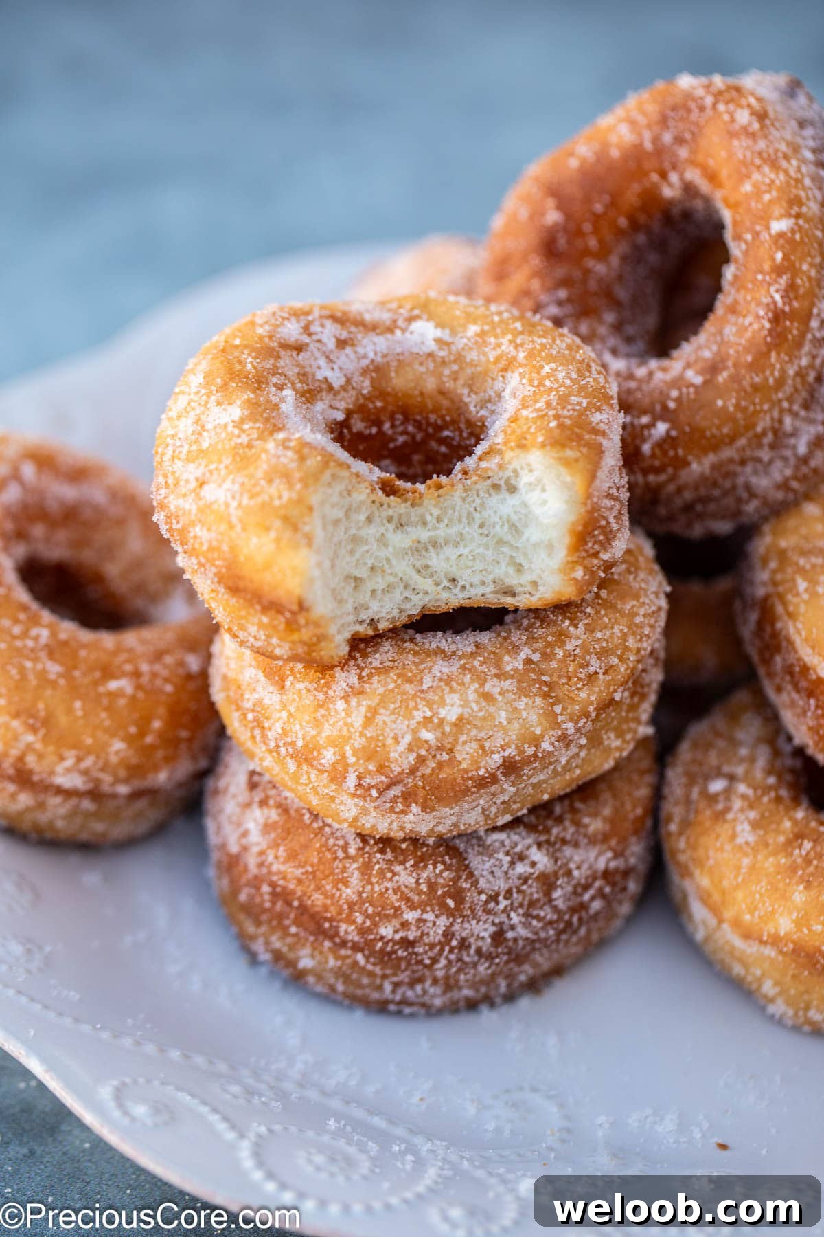 Stack of doughnuts with one missing a bite.