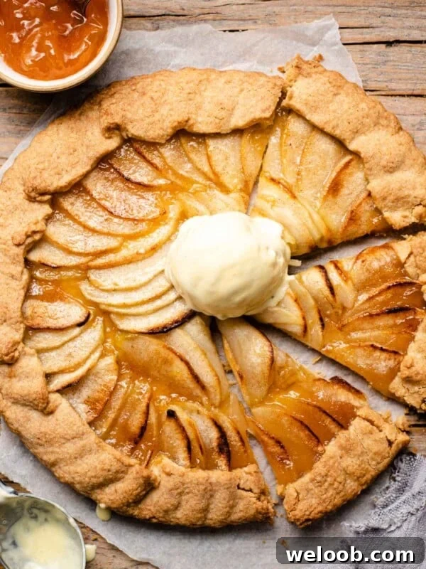 An overhead shot of an apple crostata with some slices cut and a scoop of ice cream on top